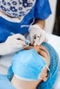 Latin Cosmetologist preparing to mexican woman for eyebrow permanent makeup procedure in Mexico, Microblading closeup