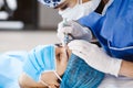 Latin Cosmetologist preparing to mexican woman for eyebrow permanent makeup procedure in Mexico, Microblading closeup