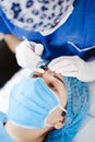 Latin Cosmetologist preparing to mexican woman for eyebrow permanent makeup procedure in Mexico, Microblading closeup