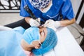 Latin Cosmetologist preparing to mexican woman for eyebrow permanent makeup procedure in Mexico, Microblading closeup