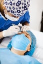 Latin Cosmetologist preparing to mexican woman for eyebrow permanent makeup procedure in Mexico, Microblading closeup