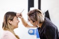 Latin Cosmetologist preparing to mexican woman for eyebrow permanent makeup procedure in Mexico, Microblading closeup