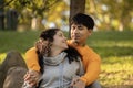 Latin couple hugging and flirting in an urban park sitting in the grass and looking each other Royalty Free Stock Photo