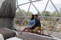 Latin couple in love inside glamping dome room with desert vegetation outside