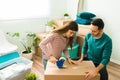 Pretty woman and man moving out and putting tape on a box Royalty Free Stock Photo