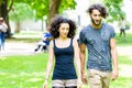 Latin Couple walking holding hands over meadow