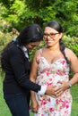 Latin daughter holds her mother`s hands on her pregnant belly