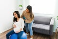 Latin doula massaging the shoulders of a pregnant woman Royalty Free Stock Photo