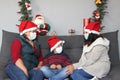 Latin family, grandmother, mom and child with protection mask and santa claus hat, christmas decoration, new normal covid-19 Royalty Free Stock Photo