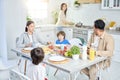 Latin family having dinner together at home. Woman serving a meal for her husband and children, standing in the kitchen Royalty Free Stock Photo