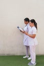 Latin Female nurses using digital tablet in hospital corridor Royalty Free Stock Photo