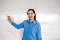 Latin Female school teacher looks at camera in classroom speaking virtual teaching remote class, online lesson, e-learning video Royalty Free Stock Photo