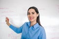 Latin Female school teacher looks at camera in classroom speaking virtual teaching remote class, online lesson, e-learning video Royalty Free Stock Photo