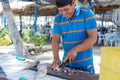 Fisherman cleaning fish at local market Royalty Free Stock Photo