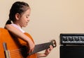 Latin girl playing acoustic guitar next to the amplifier Royalty Free Stock Photo