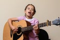 Latin girl playing electroacoustic guitar next to the amplifier Royalty Free Stock Photo