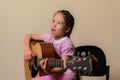 Latin girl playing electroacoustic guitar next to the amplifier Royalty Free Stock Photo