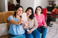 Latin Girls having fun at home taking selfie photo, laughing and drinking coffee in Mexico city