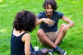 Latin Hipster couple sitting on meadow Royalty Free Stock Photo