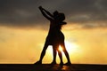 latin hispanic couple is dancing bachata above sea on summer beach. Sunset over water.Two silhouettes against the sun. Just Royalty Free Stock Photo