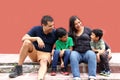 Latin, Hispanic family of mom, dad and children are sitting in the park they look happy enjoying quality time together in harmony Royalty Free Stock Photo