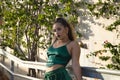 Latin and Hispanic girl, young and rebellious, with green velvet top and pants, posing in a sensual and provocative attitude.