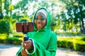 latin hispanic wonan in green muslim hijab with bright make up and nose piercing taking video stream outdoors summer