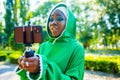 latin hispanic wonan in green muslim hijab with bright make up and nose piercing taking video stream outdoors summer