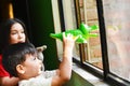 Latin kids playing with toys near the window. Quarantine. Self-isolation.