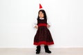 Latin little girl with elegant party dress and Christmas hat dances with happiness for the arrival of December and celebrate Chris Royalty Free Stock Photo