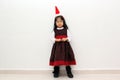 Latin little girl with elegant party dress and Christmas hat dances with happiness for the arrival of December and celebrate Chris Royalty Free Stock Photo