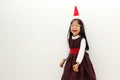 Latin little girl with elegant party dress and Christmas hat dances with happiness for the arrival of December and celebrate Chris Royalty Free Stock Photo