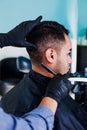 Latin man client getting haircut by hairdresser in Mexico city