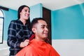 Latin man client getting haircut by hairdresser in Mexico city