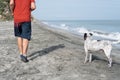 Latin Man having fun with his dog on the beach in the morning Royalty Free Stock Photo