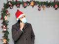 Latin man with protection mask, coat and Santa Claus hat in video call with cell phone and Christmas decoration, new normal covid Royalty Free Stock Photo