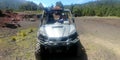 Latin man with protective helmet driving off-road car in forest field outdoors Royalty Free Stock Photo