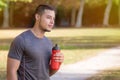 Latin man runner looking thinking water bottle running jogging sports training fitness copyspace copy space
