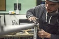 Latin man sanding a bicycle frame at his workshop