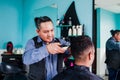 Latin man stylist cutting hair to a client in a barber shop in Mexico Royalty Free Stock Photo