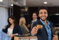 Latin Man In Suit Hold Credit Card Happy Smiling While Shopping In Elegant Menswear Store