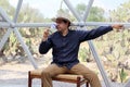 Latin man tourist with hat inside glamping room in mexico desert and drinking lemonade