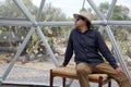 Latin man tourist with hat inside glamping room in mexico desert and drinking lemonade