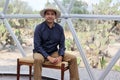 Latin man tourist with hat inside glamping room in mexico desert and drinking lemonade