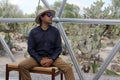 Latin man tourist with hat inside glamping room in mexico desert and drinking lemonade