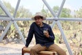 Latin man tourist with hat inside glamping room in mexico desert and drinking lemonade