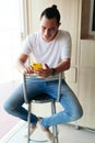 Latin man using a smartphone while sitting in the living room of his home Royalty Free Stock Photo