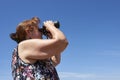 Latin mature woman looking through binoculars, Palmar National Park, Argentina Royalty Free Stock Photo