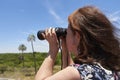 Latin mature woman looking through binoculars, Palmar National Park, Argentina Royalty Free Stock Photo