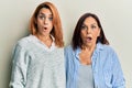 Latin mother and daughter wearing casual clothes scared and amazed with open mouth for surprise, disbelief face
